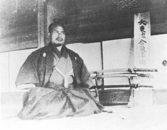 Morihei Ueshiba assis en seiza dans son dojo d’Ayabe en 1922